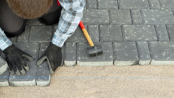 tradesperson installing block paving