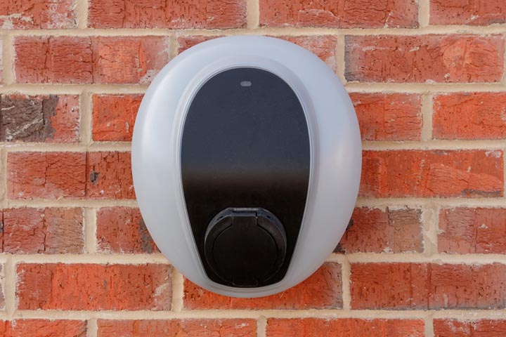 Private electric vehicle charging station fitted to the face of a red brick wall